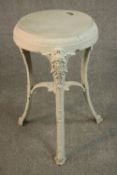 A Victorian white painted cast iron pub table, circular, raised on three curved legs with mask