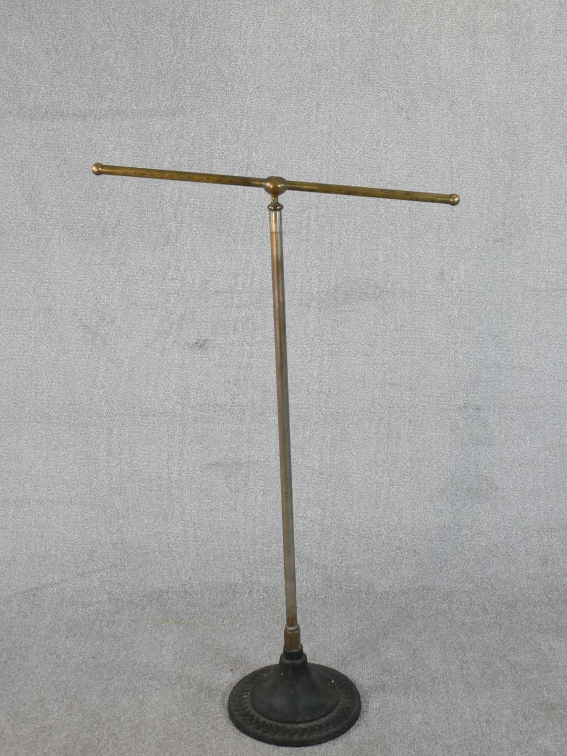 A C.1900 tubular metal towel rail of T form, on a circular cast iron base. H.121 W.72cm