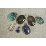 A collection seven silver and gemstone set pendants. Gemstones include: turquoise, lapis lazuli,