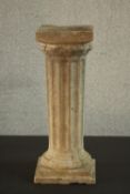 A reconstituted stone garden plinth in the form of a fluted Classical pillar, with a square step