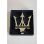 A boxed silver plated Maserati emblem paperweight. H.3 W.10 D.11.5cm. (box).