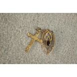 A 9 carat yellow gold engraved crucifix along with a garnet set Art Nouveau 9 carat gold pendant.