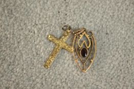 A 9 carat yellow gold engraved crucifix along with a garnet set Art Nouveau 9 carat gold pendant.