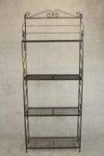 A wrought iron baker's rack, with four shelves, the sides with S shaped scrolling designs. H.194 W.