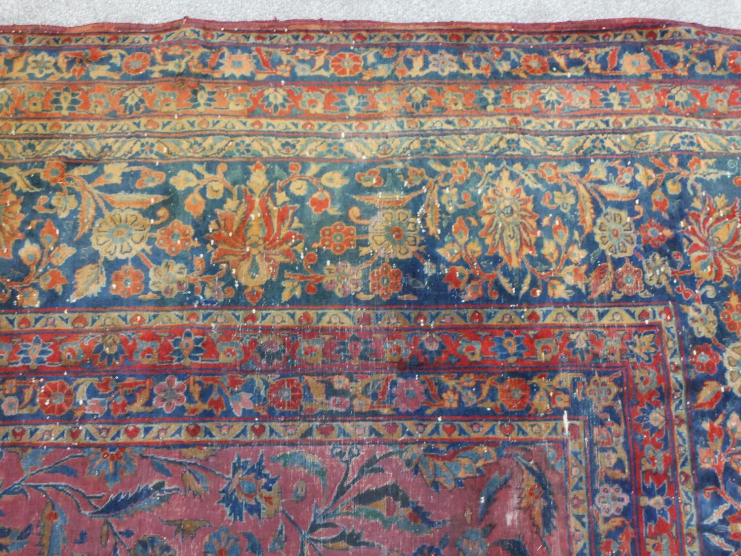 A fine hand woven Persian Sarouk carpet with scrolling foliate decoration across the burgundy - Image 5 of 7