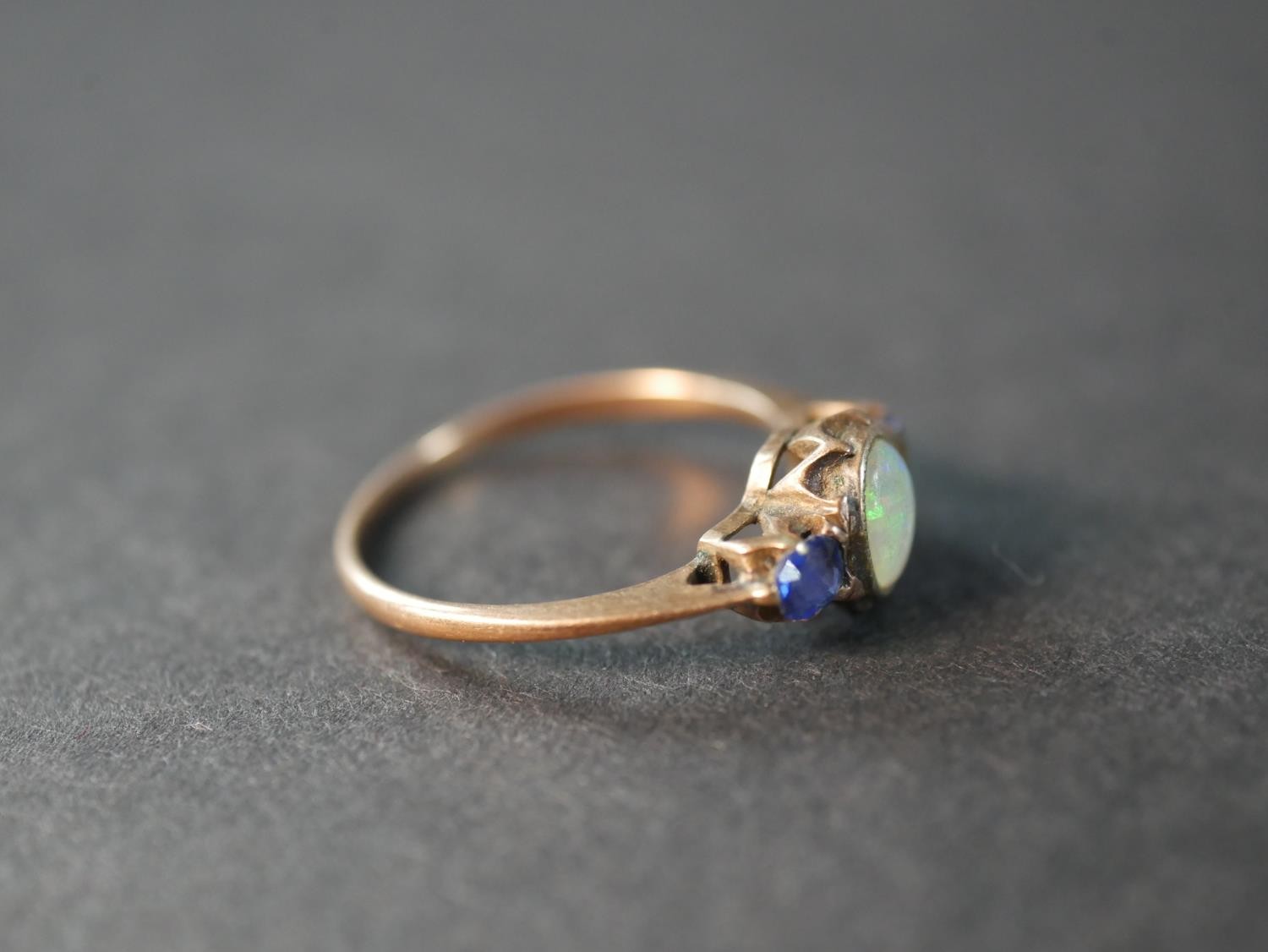 A pink metal (test as 9ct) opal and sapphire three stone ring, set to centre with an oval cabochon - Image 4 of 4