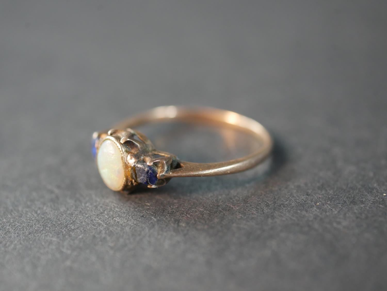 A pink metal (test as 9ct) opal and sapphire three stone ring, set to centre with an oval cabochon - Image 2 of 4