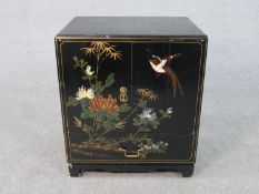 A Chinese chrysanthemum and bird decorated black lacquered and gilt cabinet with drawer and doors on