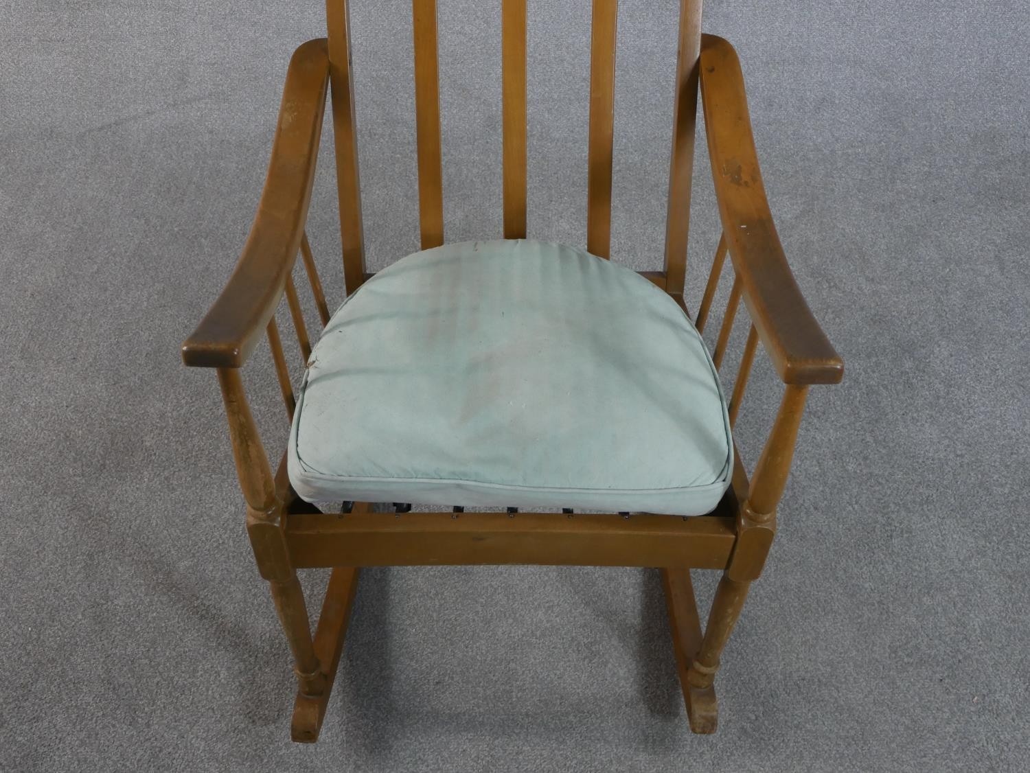 A mid 20th century beech rocking chair, with a spindle back and a blue upholstered loose cushion, on - Image 2 of 5