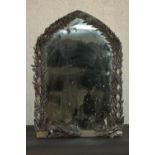 A grotto style mirror of arched form, the frame applied with leaves. (damaged).