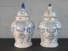 A pair of early 20th century blue and white porcelain Chinese lidded burial jars decorated with