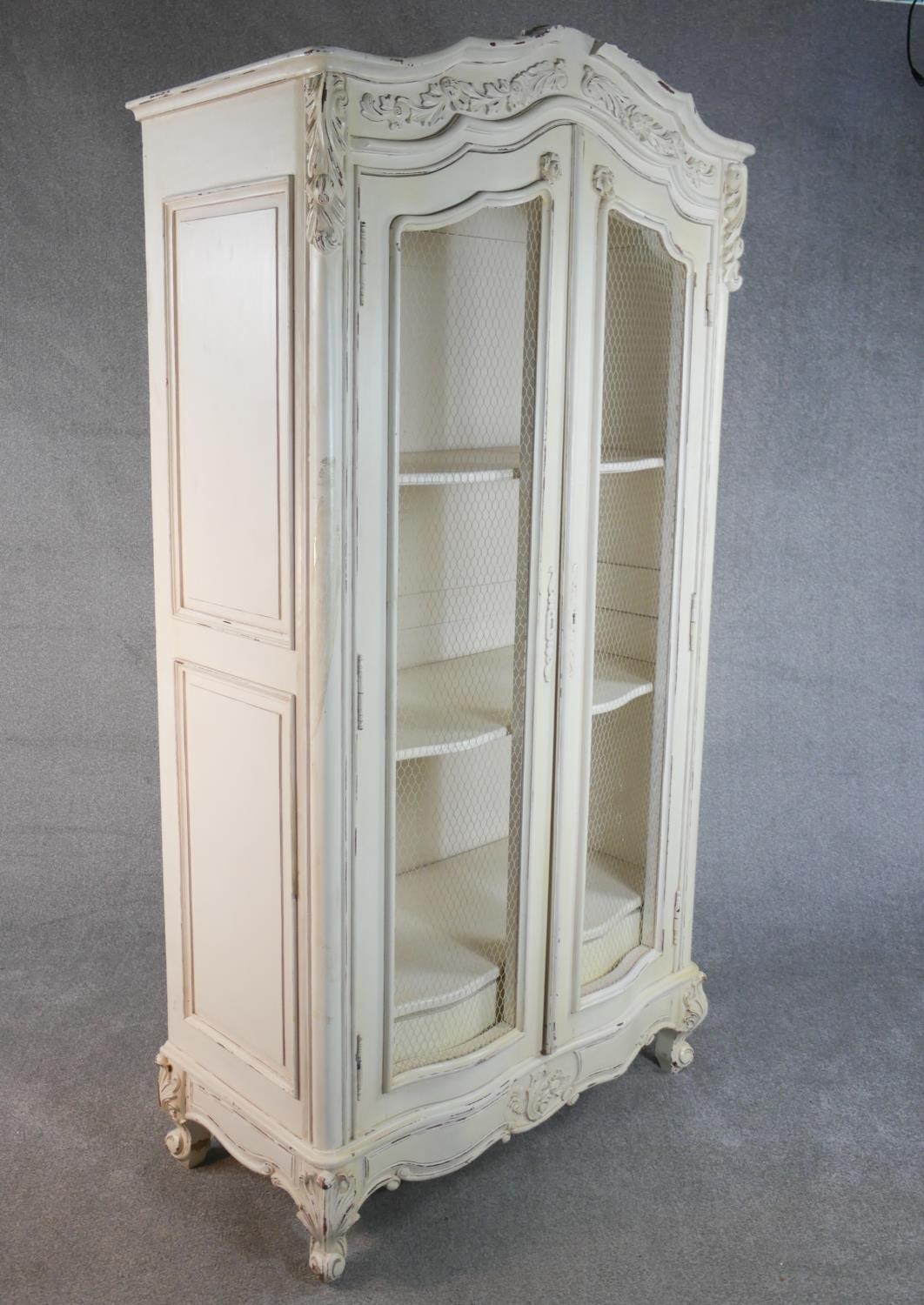 A French white painted and distressed bibliotheque, the carved cornice over two doors with mesh - Image 2 of 7
