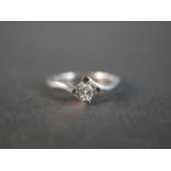 A 9 carat white gold cross over diamond solitaire ring, set to centre with a round brilliant cut
