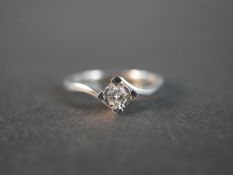 A 9 carat white gold cross over diamond solitaire ring, set to centre with a round brilliant cut