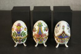 A set of three contemporary Mirai Systems enamelled ceramic eggs, polychrome decorated, with lids,