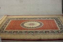 A woollen Aubusson motif carpet with central patera medallion on a burgundy ground within