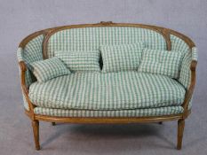 A carved Louis XVI style canape reupholstered in a retro style pale sage patterned material. H.91