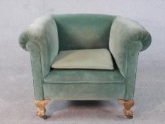 A mid century tub armchair on carved walnut cabriole ball and claw supports