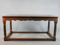 An early 20th century oak refectory dining table, the rectangular top with rounded corners over a