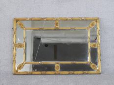A Regency gilt framed sectional wall mirror, of rectangular form, the reed and ribbon frame joined
