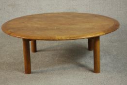 A mid 20th century circular teak coffee table, with a crossbanded edge, on cylindrical legs. H.35