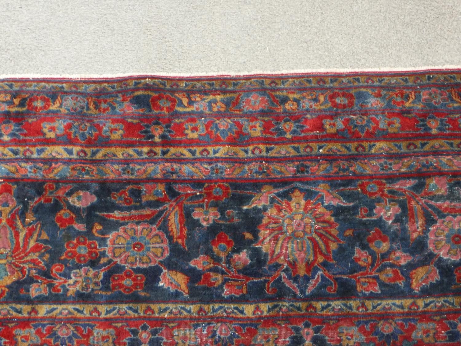 A fine hand woven Persian Sarouk carpet with scrolling foliate decoration across the burgundy - Image 6 of 7