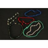 A collection of necklaces and knotted beads including a graduated malachite bead necklace, a