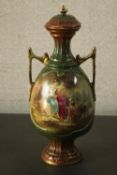 A Victorian twin handled hand painted ceramic lidded urn decorated with two female figures and