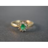 A 9 carat gold vintage emerald and diamond cluster ring, set to the centre with an oval mixed cut