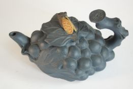 A Chinese black clay bunch of grape form tea pot with cicada finial. H.9 W.15 D.9cm.