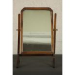 A George II style walnut swing frame toilet mirror, in a moulded frame with a reeded stand. H.62 W.