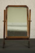 A George II style walnut swing frame toilet mirror, in a moulded frame with a reeded stand. H.62 W.