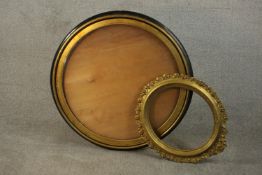 A circular ebonised and parcel gilt mirror frame, together with an oval gilt frame with a border