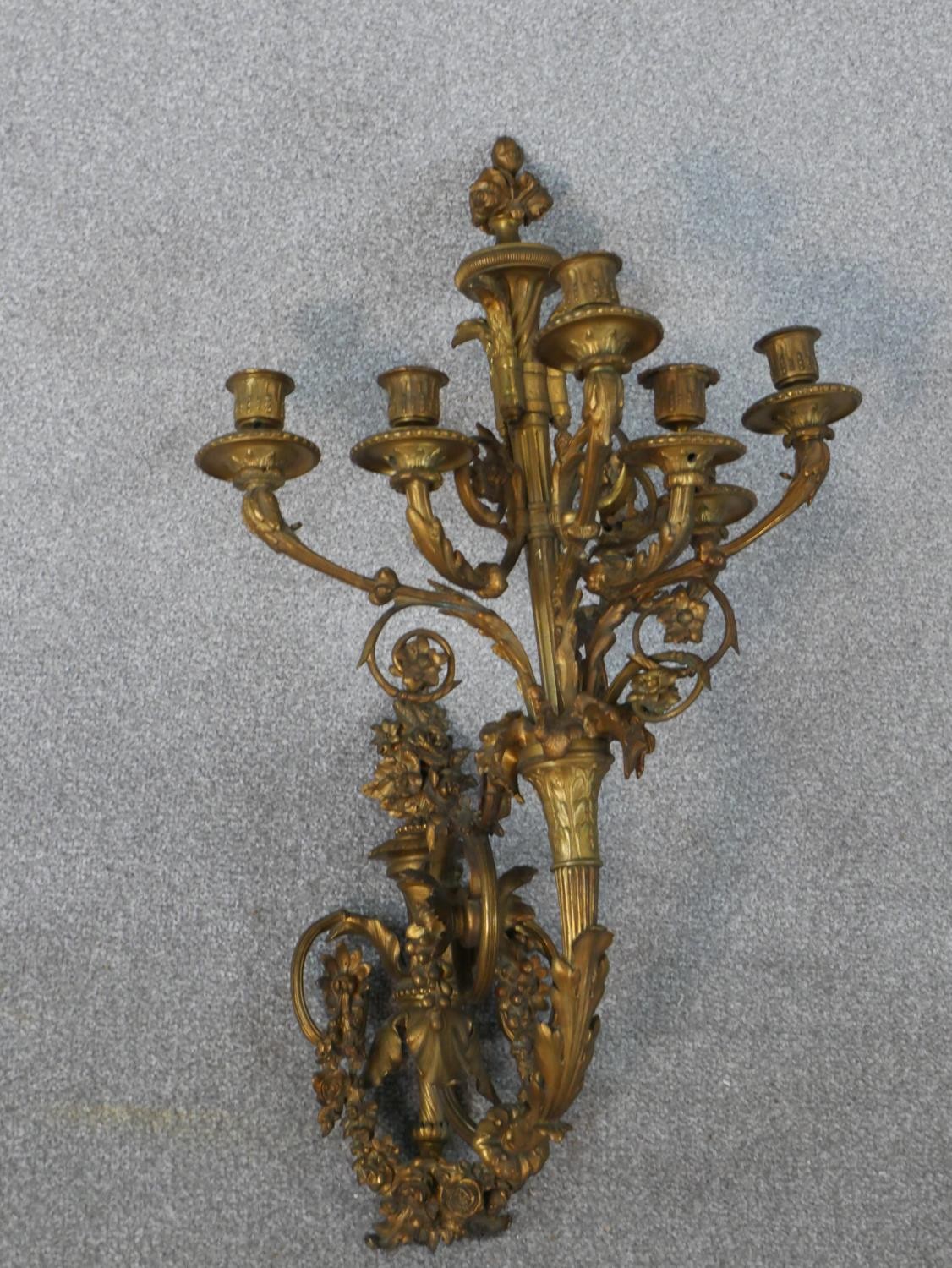 A late 19th century ormolu wall applique, the torch form wall mount hung with garlands of flowers
