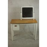 A vintage child's white painted dressing table, incorporating a square mirror on swing frame, the