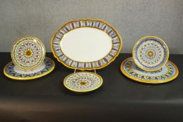 A collection of Italian hand painted ceramic majolica platters and plates, including a large oval