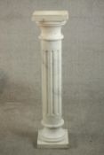 A white marble Classical style column, fluted, on a square base. H.100 W.24 D.24cm.