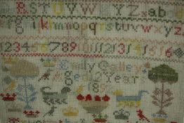 A late Victorian schoolroom sampler worked in cross-stitch with coloured thread on a large holed