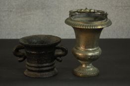 A 17th century cast iron mortar, with ribbed decoration, a flared rim and two handles, together with
