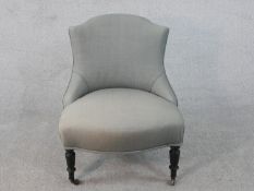 A Victorian nursing chair on turned supports reupholstered in piped calico.