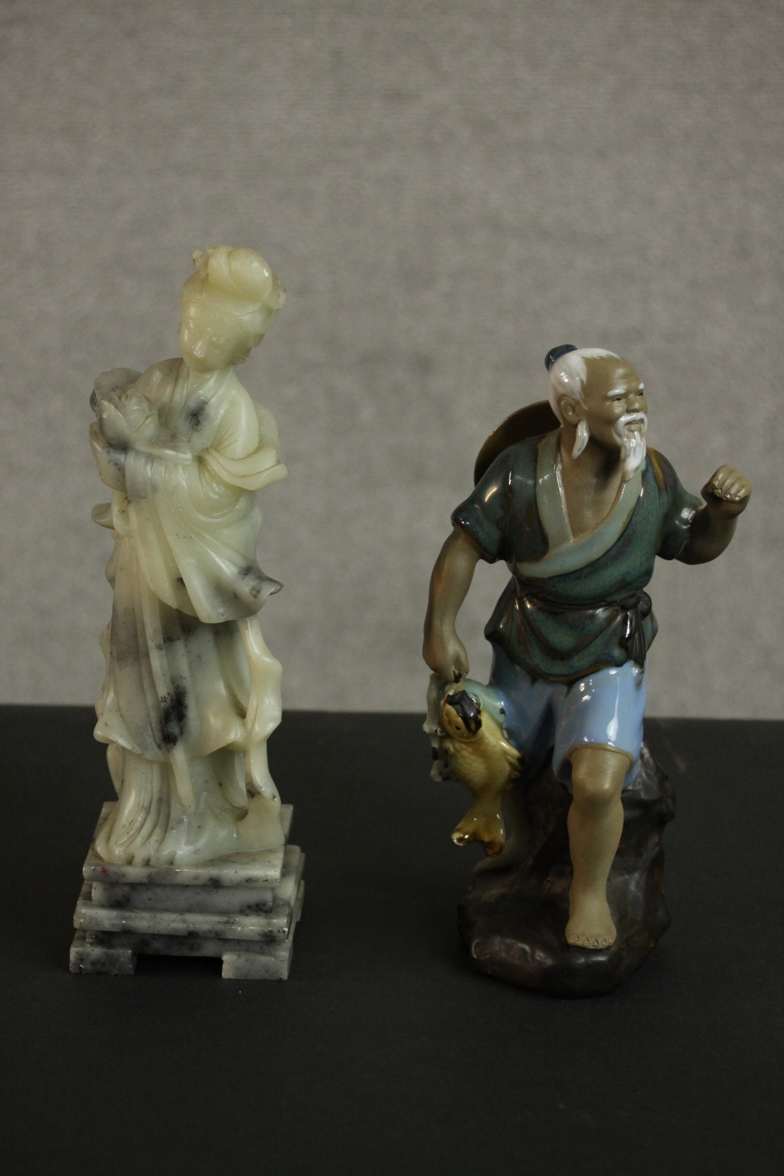 A carved Chinese soapstone figure of a female deity along with a hand painted clay figure of a