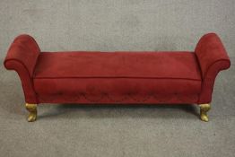 A late 20th century window seat, upholstered in red fabric with scroll ends, on carved and gilt