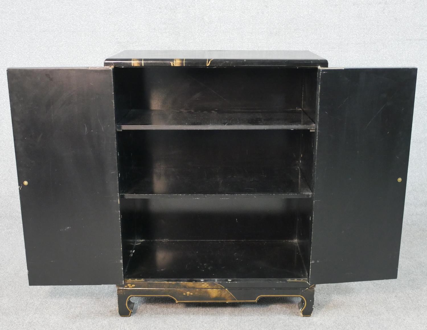 A Chinese peony and bamboo design black lacquered and gilt cabinet with two doors and three - Image 4 of 5