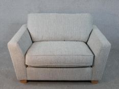 A contemporary small two seater sofa in calico upholstery.