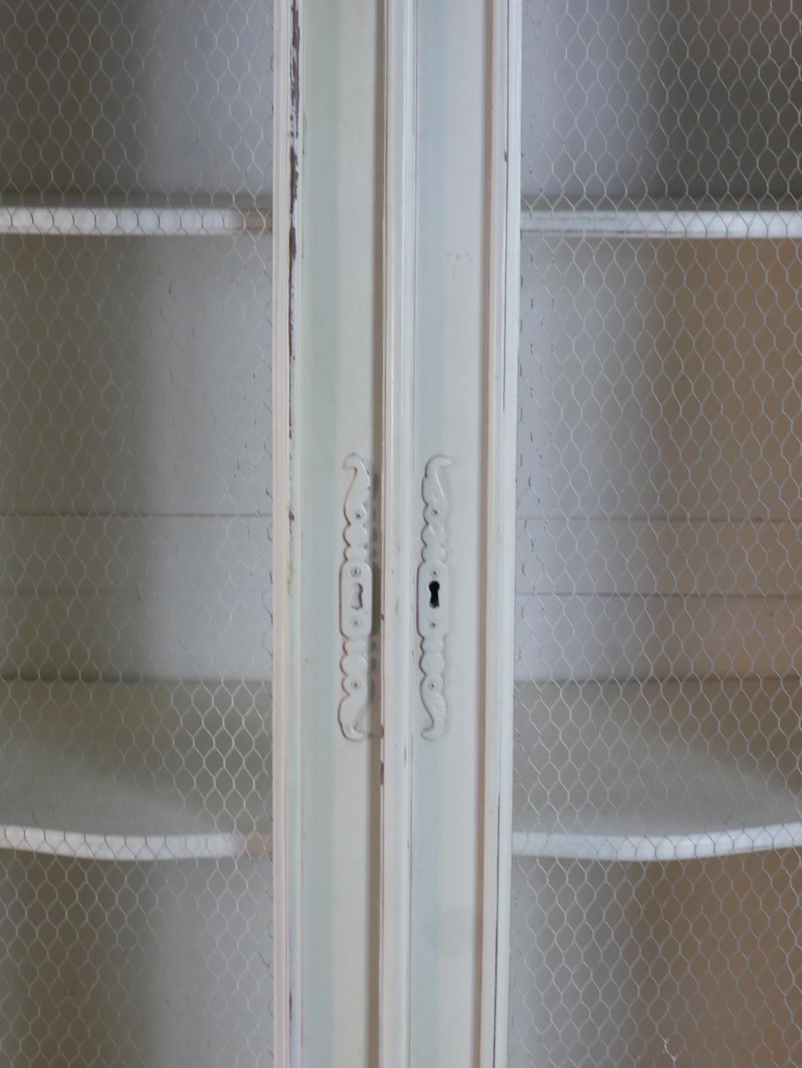 A French white painted and distressed bibliotheque, the carved cornice over two doors with mesh - Image 5 of 7