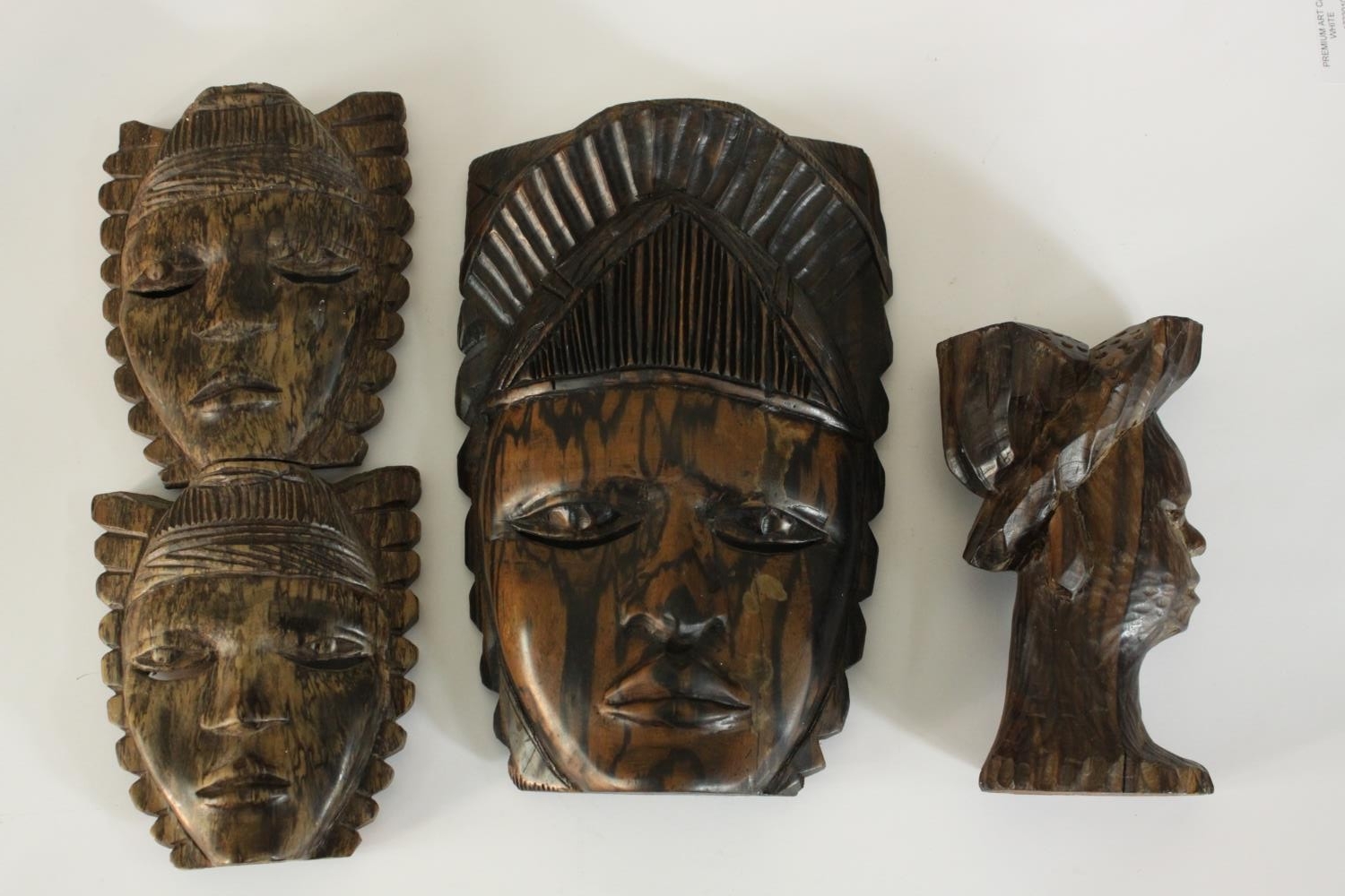 A carved African tribal mask along with a carved male bust in a hat and a double headed mask. H.27