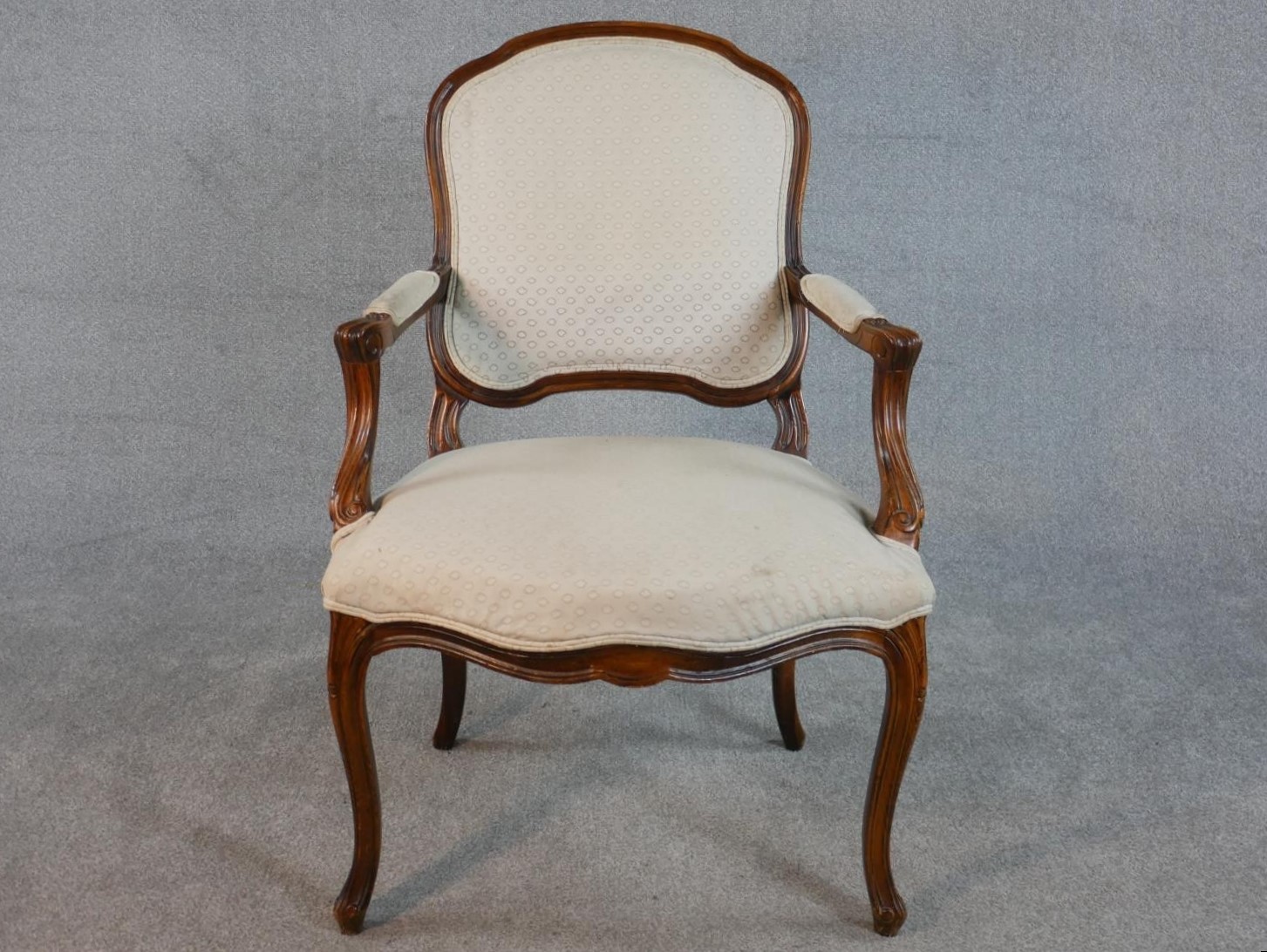 A French Louix XV style walnut fauteuil armchair, upholstered to the back, seat and arm pads with