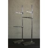 Two vintage adjustable chrome shelving store display racks on cast iron bases. H.107 W.37 D.16cm.