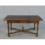 A continental walnut table, the rectangular leather top with brass studs to the edge, over a