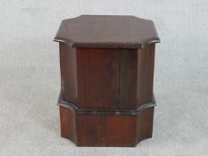 A 19th century mahogany commode, the lid with moulded edges and canted corners, raised on a plinth